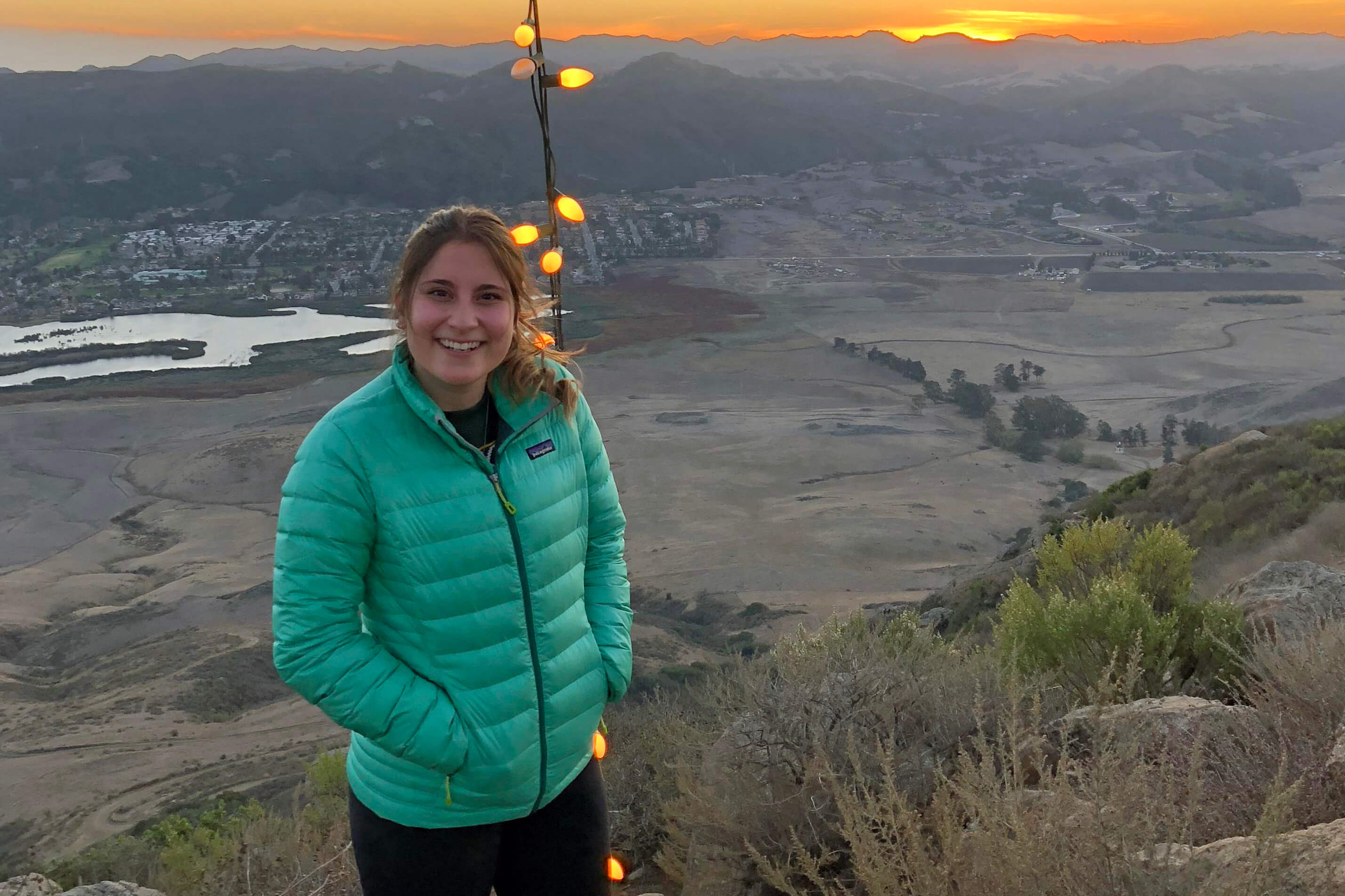 Courtney Owens standing on top of Cerro San Luis Obispo at sunset